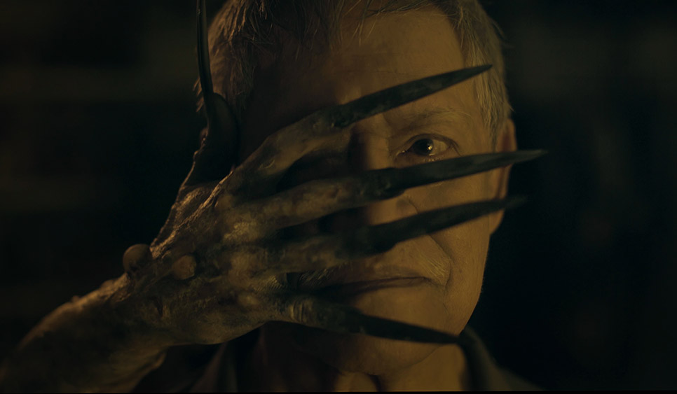 Dead Packet film still creepy hand in front of man's face.