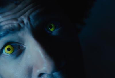 A man with yellow eyes looks up