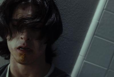 A disheveled man stands in the bathroom