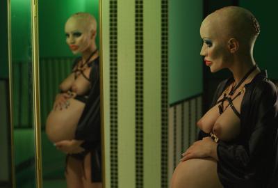 Animated bald woman looks at her pregnant belly in a mirror