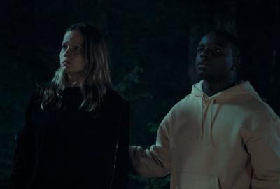 Two persons in the dark, looking frightened.