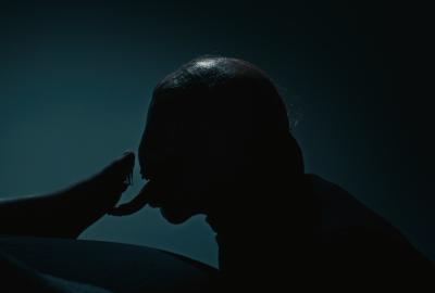 A woman leaves her foot out of the covers and is visited by someone, or something, wanting a little taste.