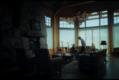A missionary stands next to an elderly woman in a wheelchair.