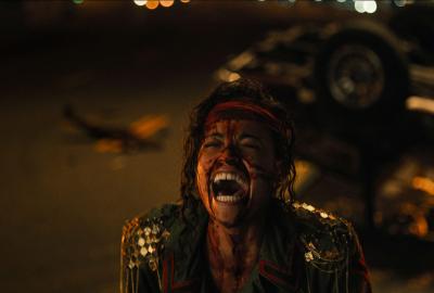 A woman covered in blood screams