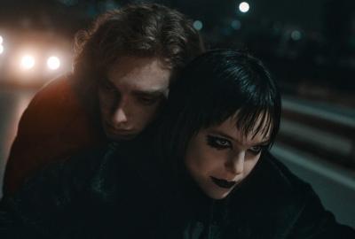 Mimi rides on a motorcycle driven by Carmilla