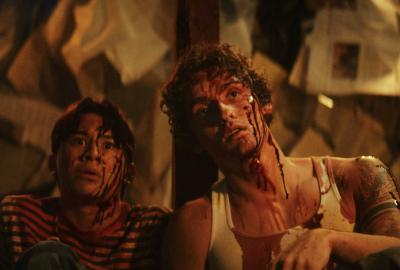 Two teenage boys covered in blood and staring in awe