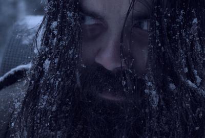 A snow covered man glares