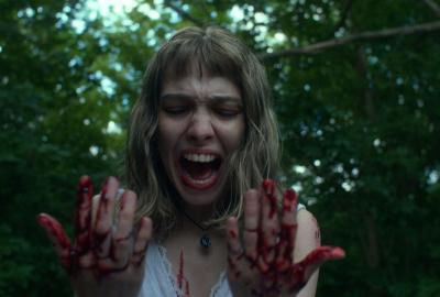 A young woman screams looking at her bloody hands