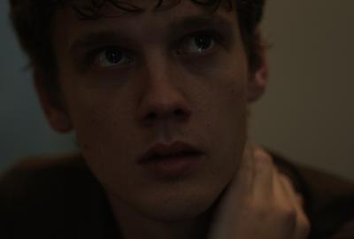 A man looks up with his hand on his neck