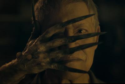 Dead Packet film still creepy hand in front of man's face.