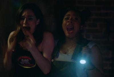 Young women with a flashlight scream in fear