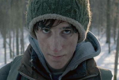 Aftermath young man walks with a rifle in the cold