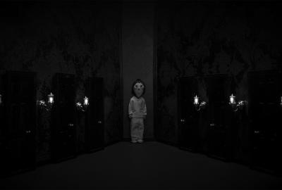 Boy stands facing us