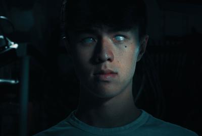 A young man stares with glossy eyes